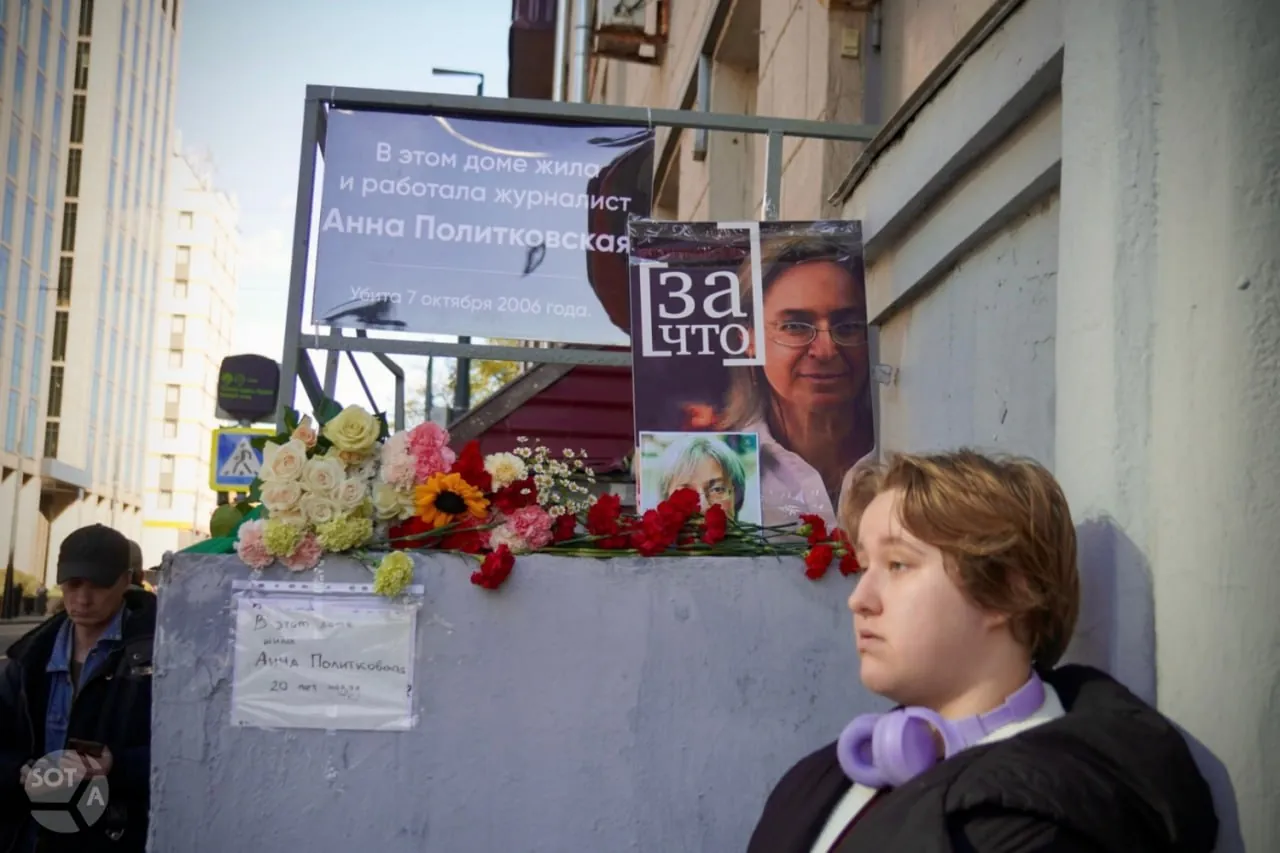Временная памятная табличка, портреты Анны Политковской и цветы у её дома на Лесной улице